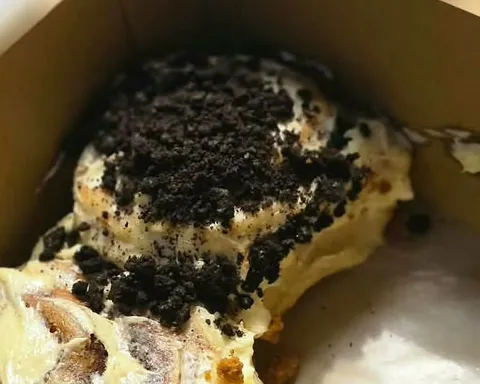Close-up of a cinnamon roll covered in chocolate cookie crumbs